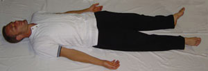 a person lying down practicing relaxation qigong
